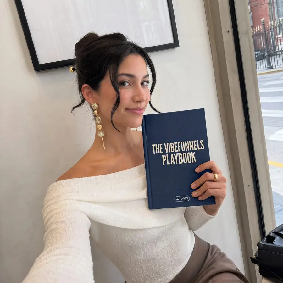 The VibeFunnels Playbook held by a reader